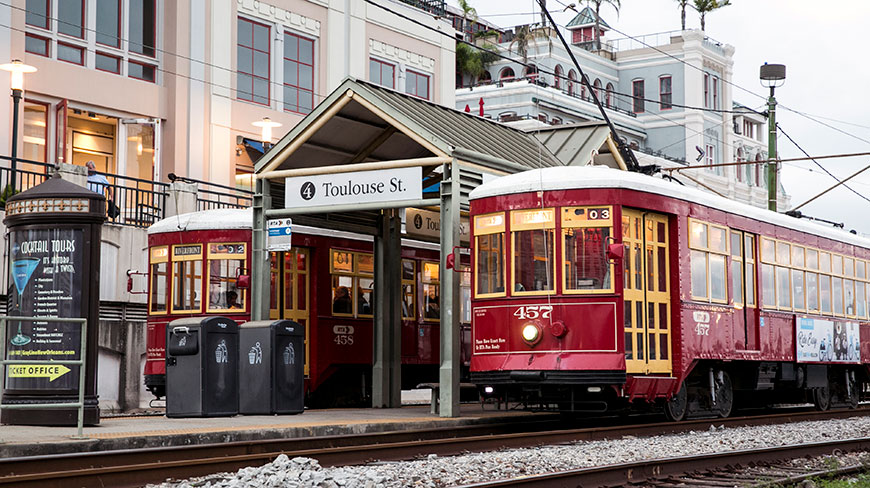 Two red streetcars wait at the Toulouse Street station in New Orleans, Louisiana.