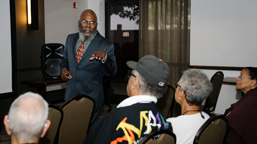 Dr. Spruill gestures while giving a presentation on the Civil Rights Movement to an engaged audience in Atlanta, Georgia.