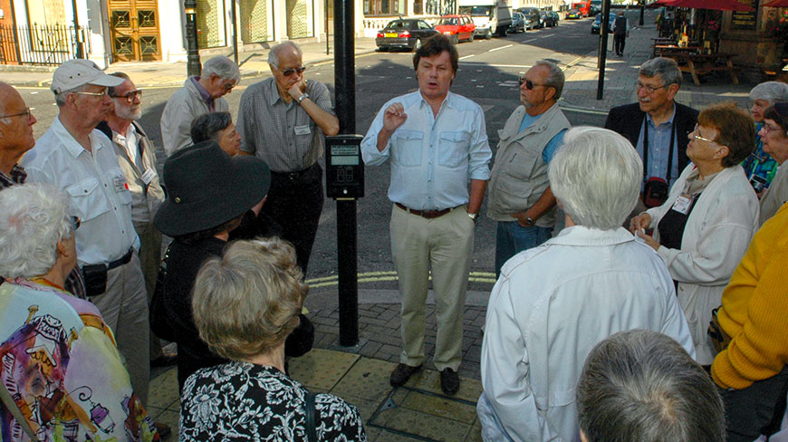 A tour guide speaks to a group of people on a street corner in Washington, D.C.