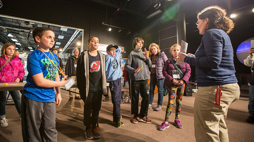 A group of children listen to a female guide at a NASA facility in Chincoteague, Virginia.
